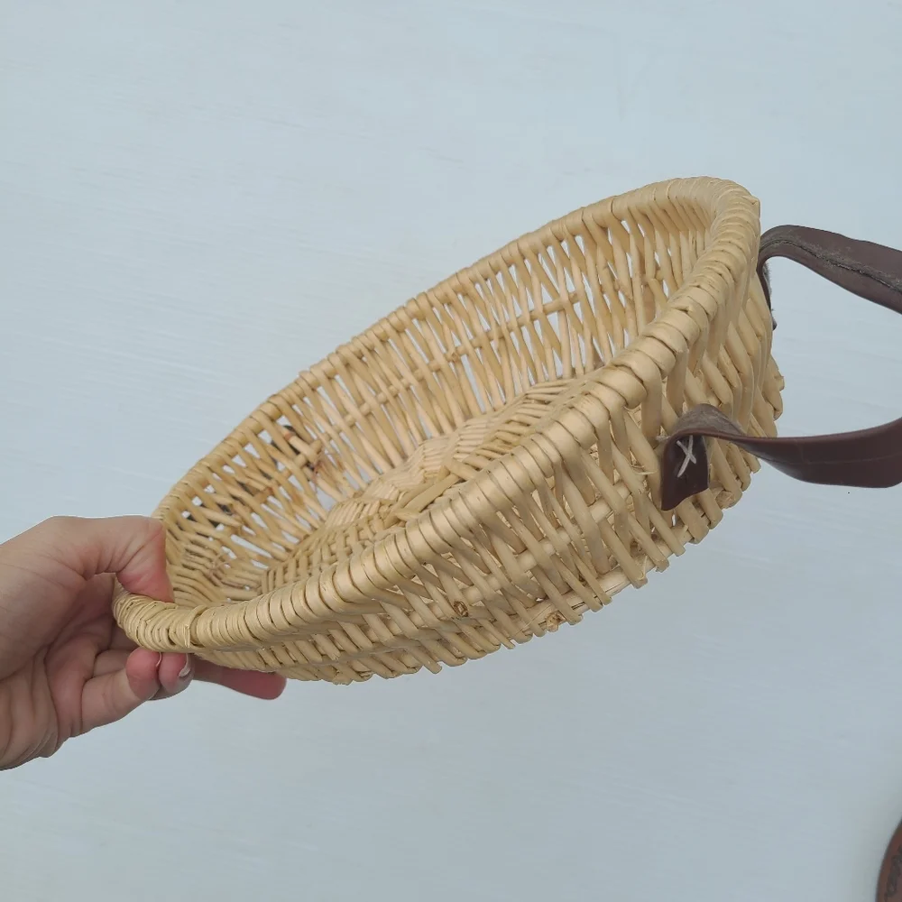 Woven wicker basket with faux leather handles
